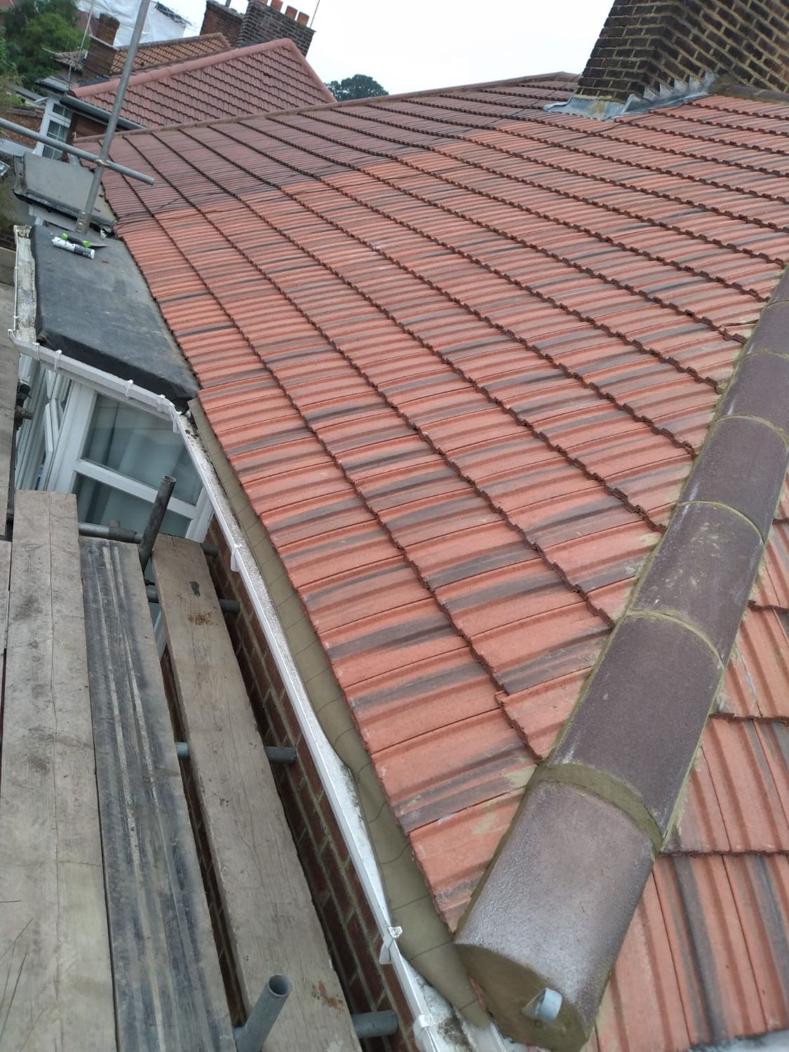 New red clay roof tiles with a ridge tile